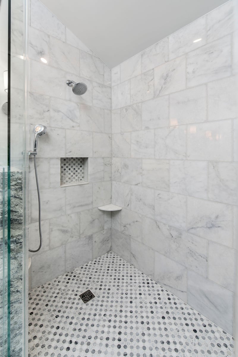 shower with controls tucked behind a half wall