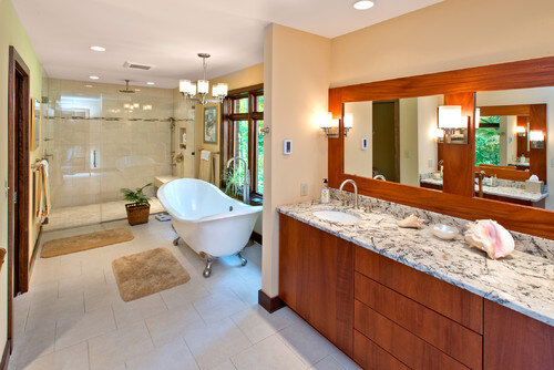 luxurious bathroom with double vanity, chandelier, and sconces